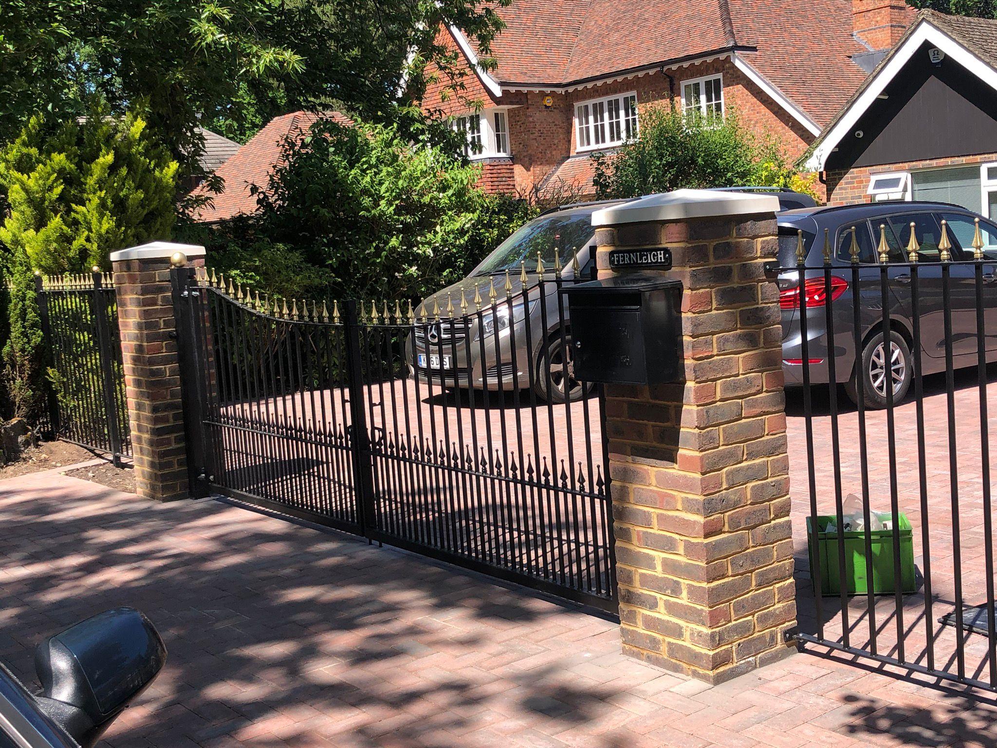 Black metal electric driveway gates with brick pillars, Surrey
