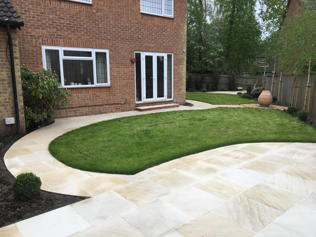 Buff sandstone curved patio with new turf lawn and French doors, Surrey