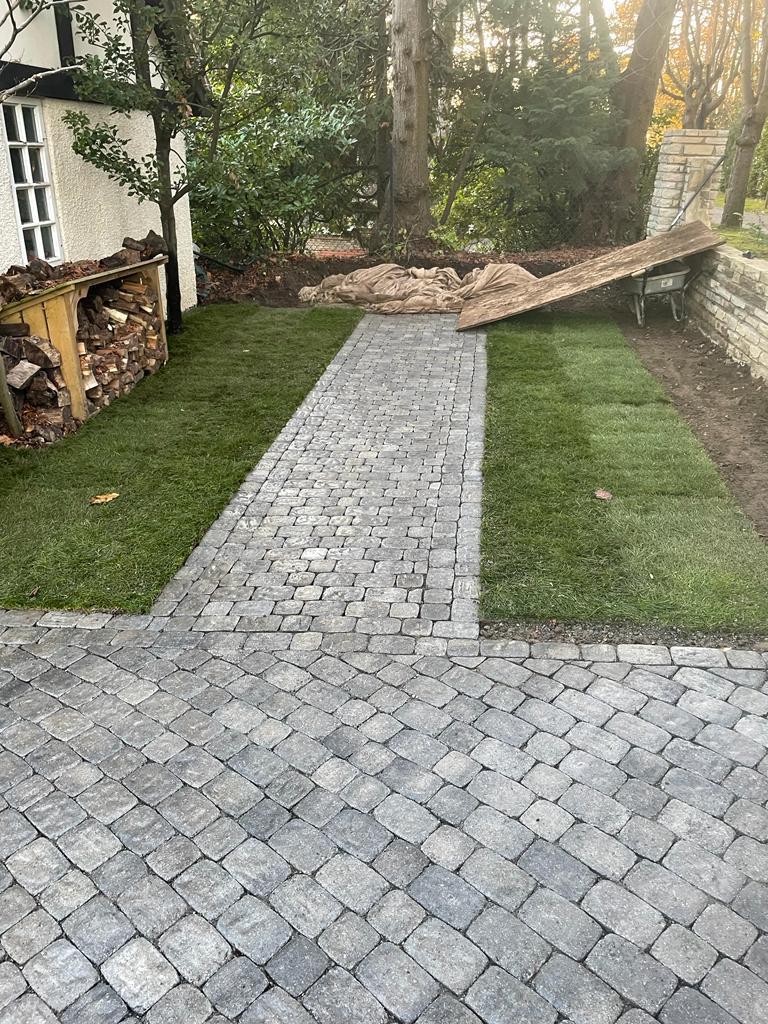 Cobblestone sett path with new turf garden in autumn, Surrey