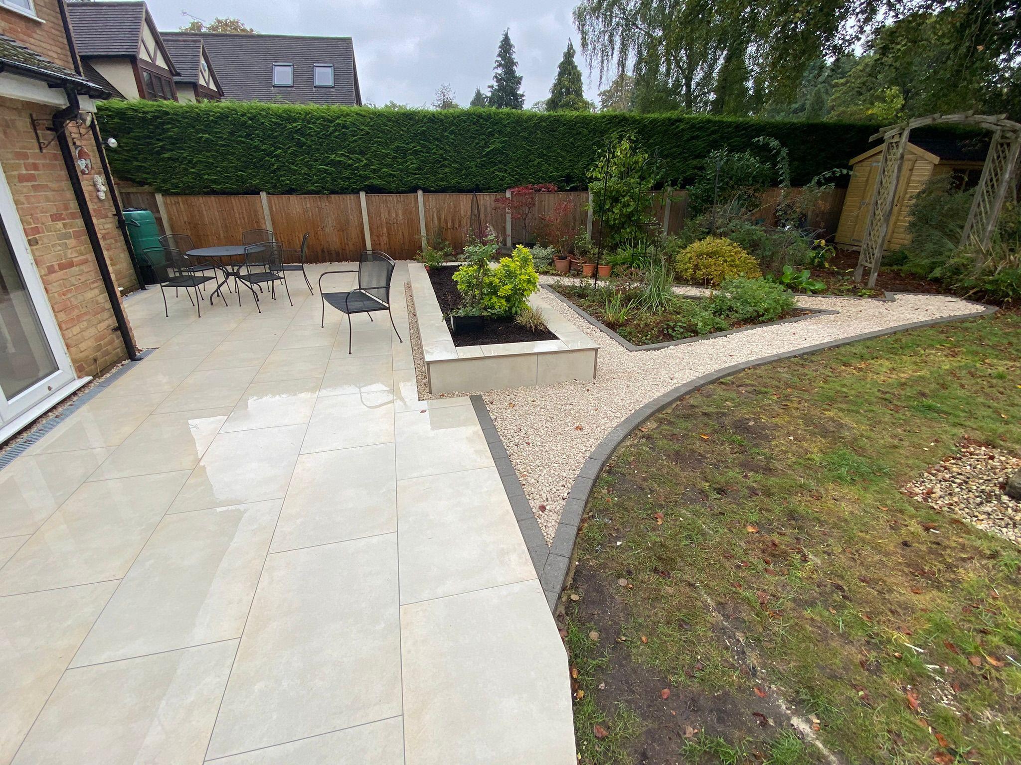Cream porcelain patio with raised planter and curved gravel border, Surrey