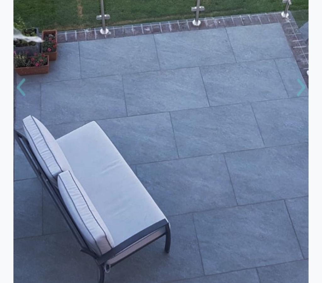 Dark grey porcelain patio aerial view with sun lounger and glass balustrade, Surrey