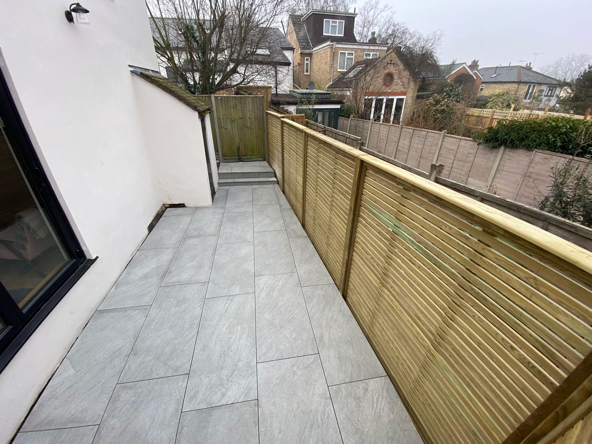 Grey porcelain patio balcony with timber balustrade, Surrey